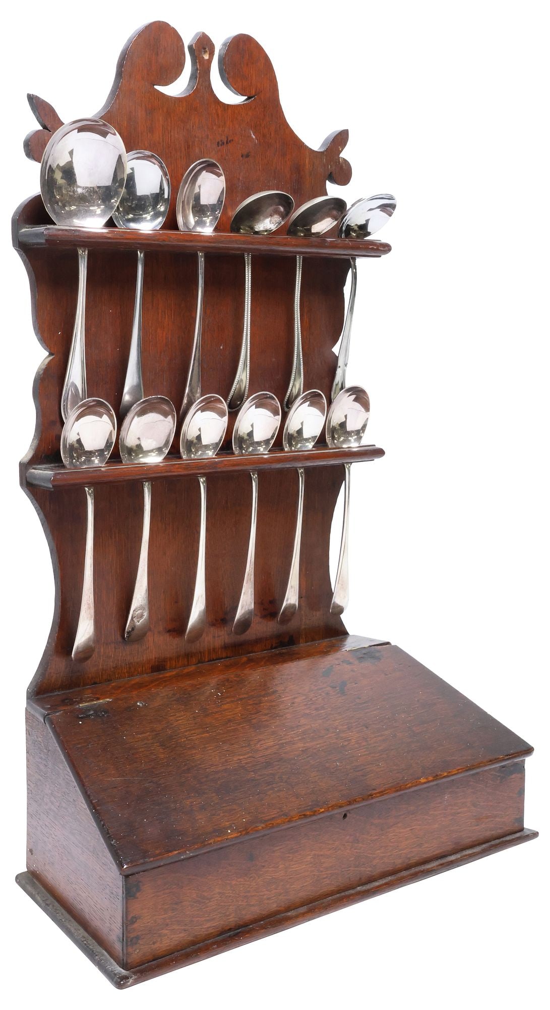 ENGLISH GEORGIAN PERIOD OAK WALL-MOUNTED SPOON RACK & SPOONS: English George III oak spoon rack, early 19th c., having scrolled pediment, above two slotted spoon racks, sloped lower case with hinged cover, accompanied by (thirteen) silverplate and other metal sp