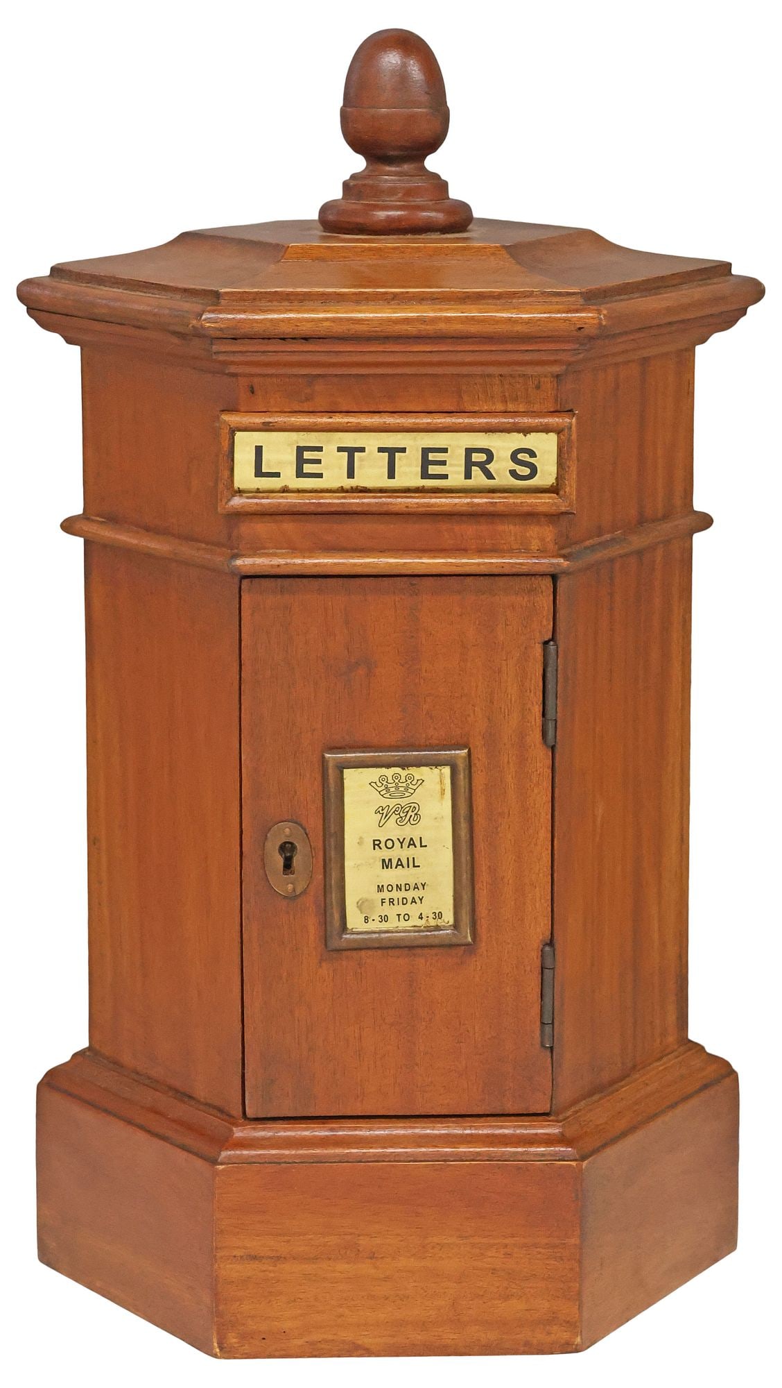 ENGLISH CARVED MAHOGANY PILLAR-FORM LETTER BOX: English mahogany letter box, late 20th/ 21st c., of pillar form, a finial surmounting the hexagonal case with brass "Letters" slot and "VR Royal Mail 8:30 TO 4:30" plaque on the single door, open inte