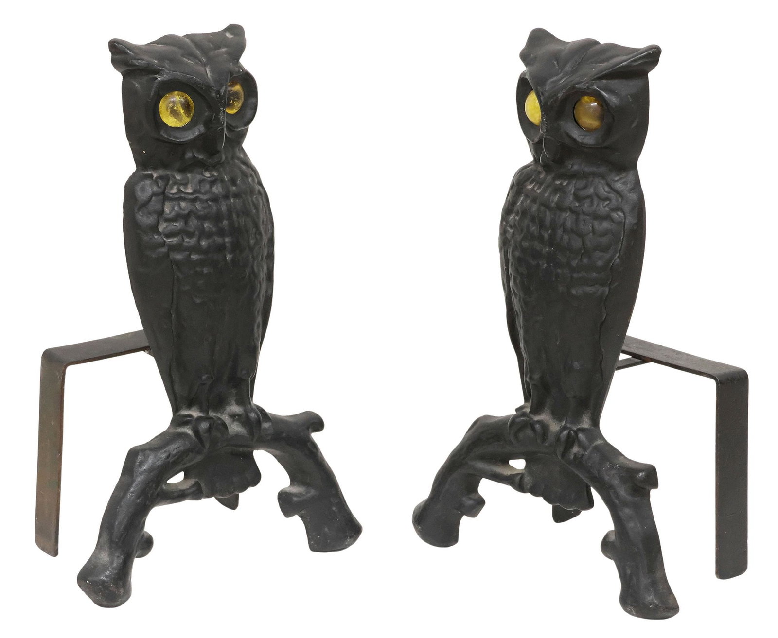 (2) CAST IRON FIGURAL OWL ANDIRONS W/ AMBER GLASS EYES, 13"H: (pair) Black-painted cast iron fireplace chenets/ andirons, each in the form of an owl, with inset yellow glass eyes, perched on a curved branch, marked M 144-U to reverse, approx 13"h, 8.25"w, 4.75"d