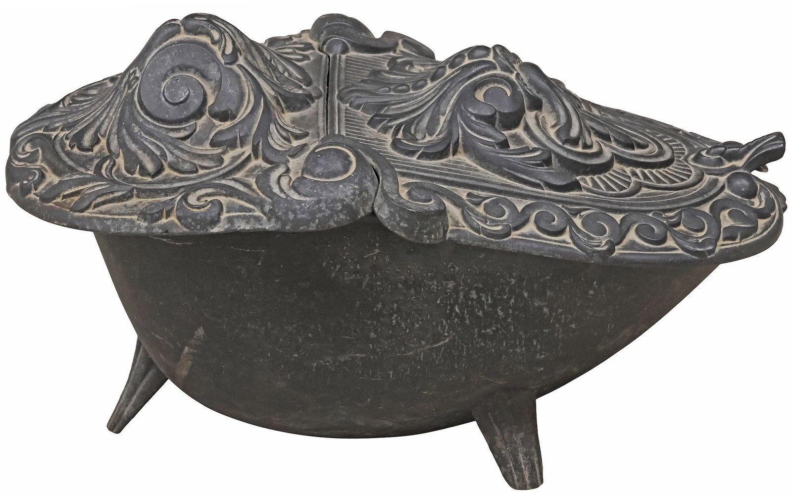 ENGLISH VICTORIAN CAST IRON COAL SCUTTLE WITH BRASS SHOVEL: English Victorian cast iron coal bin, late 19th c., having hinged cover with raised foliate scroll motifs, tapering ovular basin, on tripod legs, accompanied by (one) wood-handled brass shovel/ scoop,