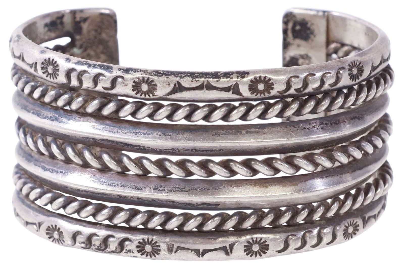 SIGNED NATIVE AMERICAN SILVER STAMP & WIREWORK CUFF BRACELET, 78.4 GRAMS: Native American silver (content unknown) cuff bracelet, four rows spaced by twisted rope wire, outer bands with stampwork motifs, signed JW to interior, approx 1.25"w, interior: approx 5 3/8"l, gap: a