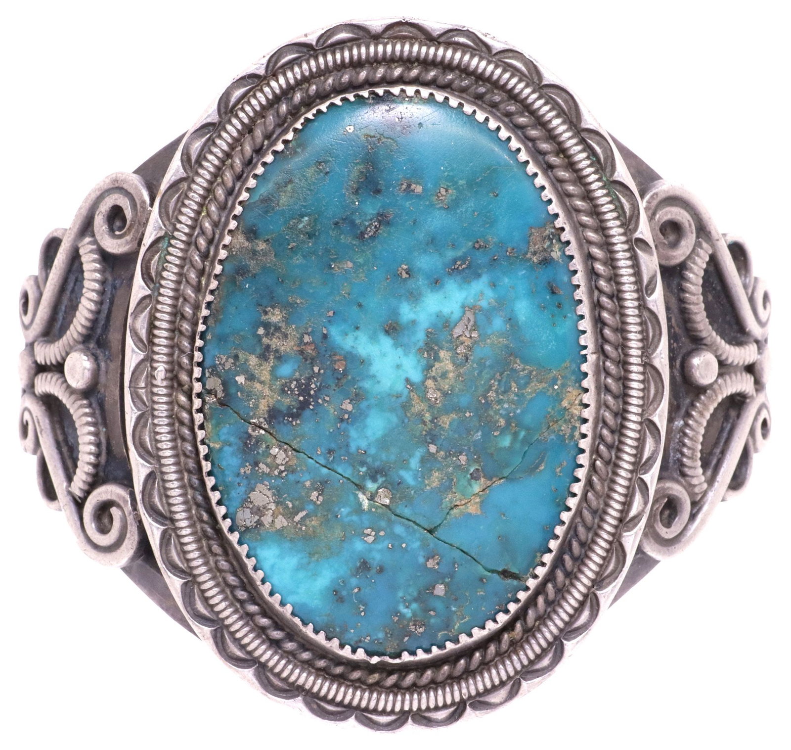NATIVE AMERICAN SILVER & OVAL TURQUOISE PLAQUE CUFF BRACELET: Native American silver (content unknown) cuff bracelet, bezel-set central oval turquoise plaque with metallic flecks in the matrix, framed by twisted wire, over split shank with scrolled accents and s