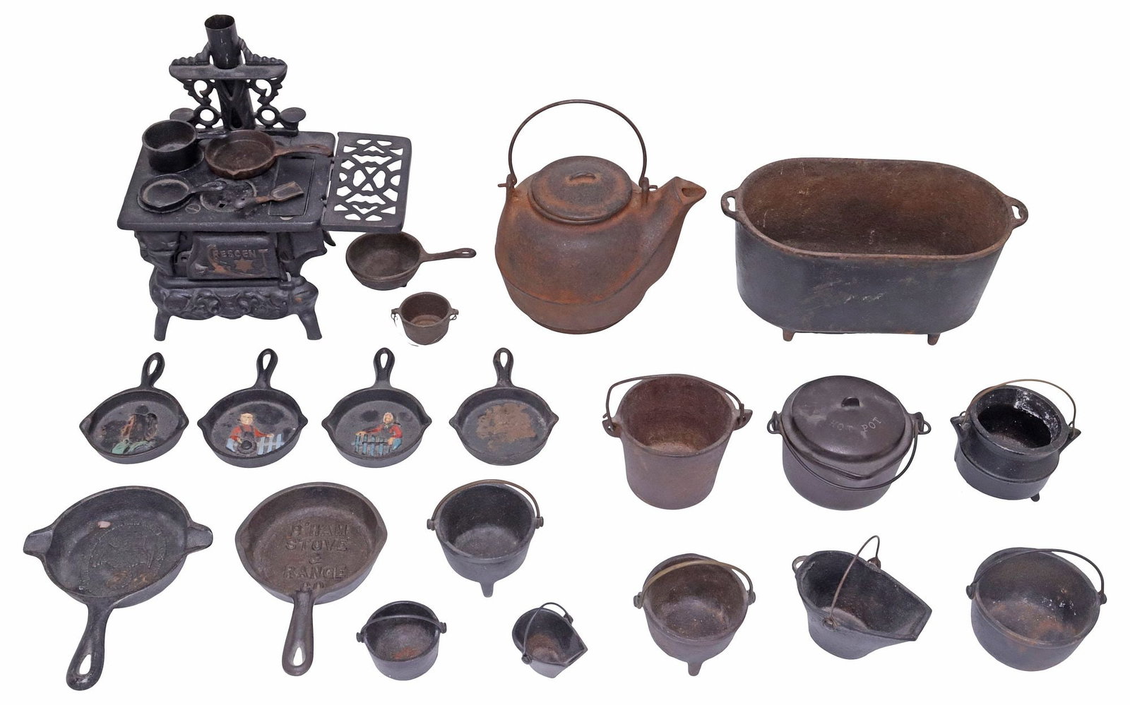 (LOT) COLLECTION OF CAST IRON MINIATURE STOVE & KITCHENWARE, WAGNERS: (lot) Collection miniature cast iron kitchenware and table items, various sizes and makers, highlights include: (1) Regent stove, likely a salesman sample, (1) Wagner Manufacturing Company covered cau