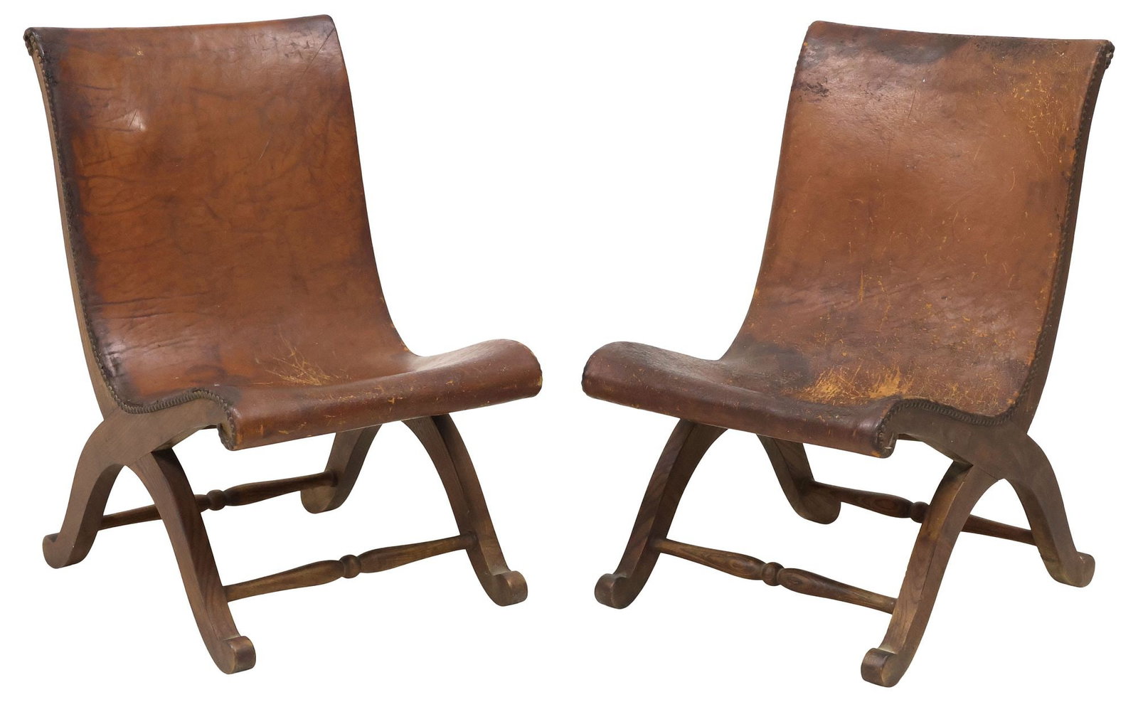 (2) SPANISH RENAISSANCE REVIVAL LEATHER & OAK CURULE SLIPPER CHAIRS: (pair) Renaissance Revival oak slipper chairs, Spain, early 20th c., each in worn brown leather upholstery, with nail-head trim, rising on curule base, approx 29.75"h, 18"w, 24"d, seat 