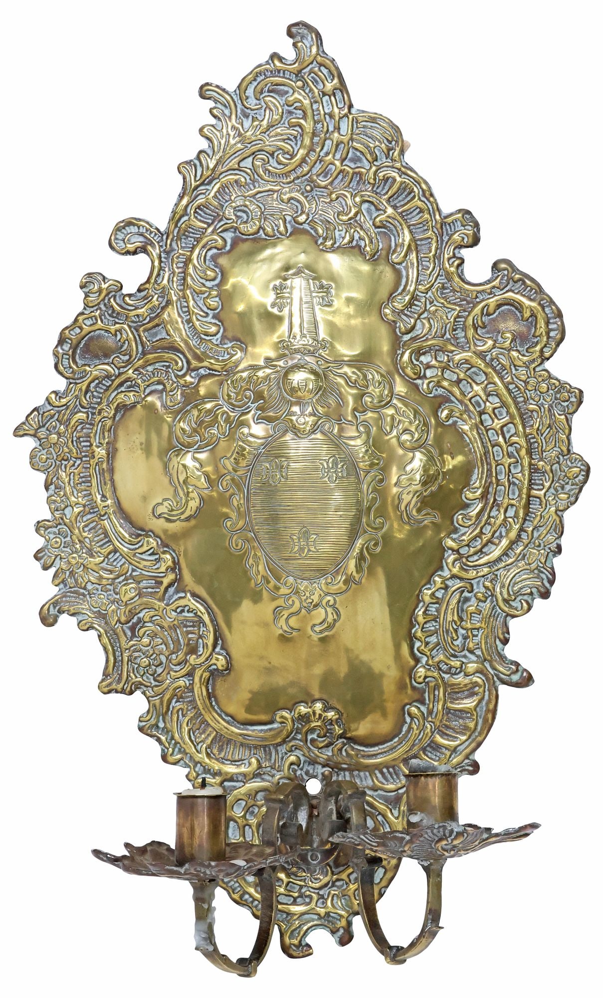 CONTINENTAL BAROQUE STYLE BRASS REPOUSSE ARMORIAL 2-LT SCONCE: Continental Baroque style brass repousse two-light candle sconce, 19th c., shaped plaque with scrolling foliate border, centering a heraldic coat of arms, above two scrolled arms terminating on florif