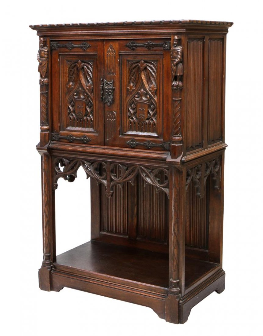 ANTIQUE GOTHIC REVIVAL CARVED CABINET: French Renaissance Revival oak cabinet, c. 1900, the a rectangular top over over a pair of figures flanking two doors with Gothic decoration extending to the pierced carved skirt below, the open base