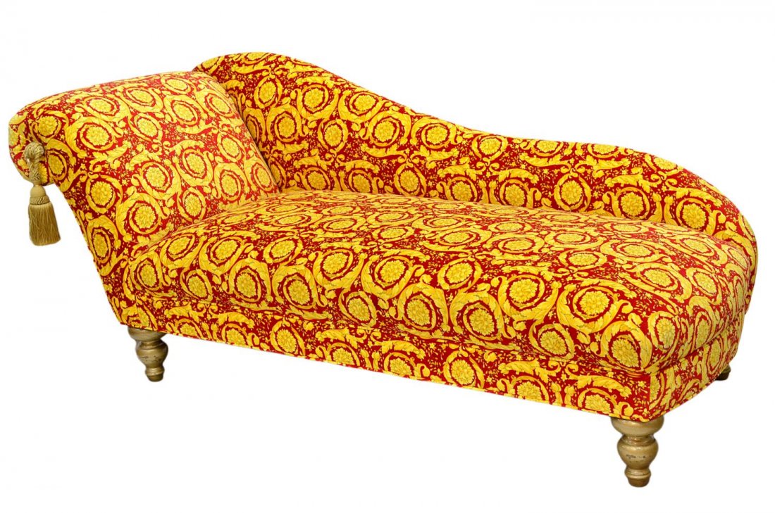 VERSACE FABRIC UPHOLSTERED CHAISE LOUNGE: Chaise lounge reupholstered with Versace red and gold foliate fabric, high end with tassel at front, set on turned bulbous feet, 33.5"h, 75"w, 32.5"d Start Price: $500.00