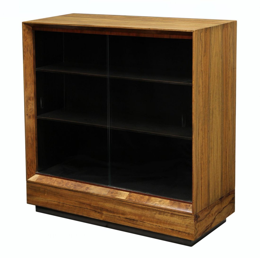 PALDAO BOOKCASE, GILBERT ROHDE FOR HERMAN MILLER: Paldao wood bookcase, design, c. 1940, by Gilbert Rohde (1894-1944) for Herman Miller, rectangular with two sliding glass doors opening to interior shelves, 42"h, 40"w, 17"d Start Price: $200.00