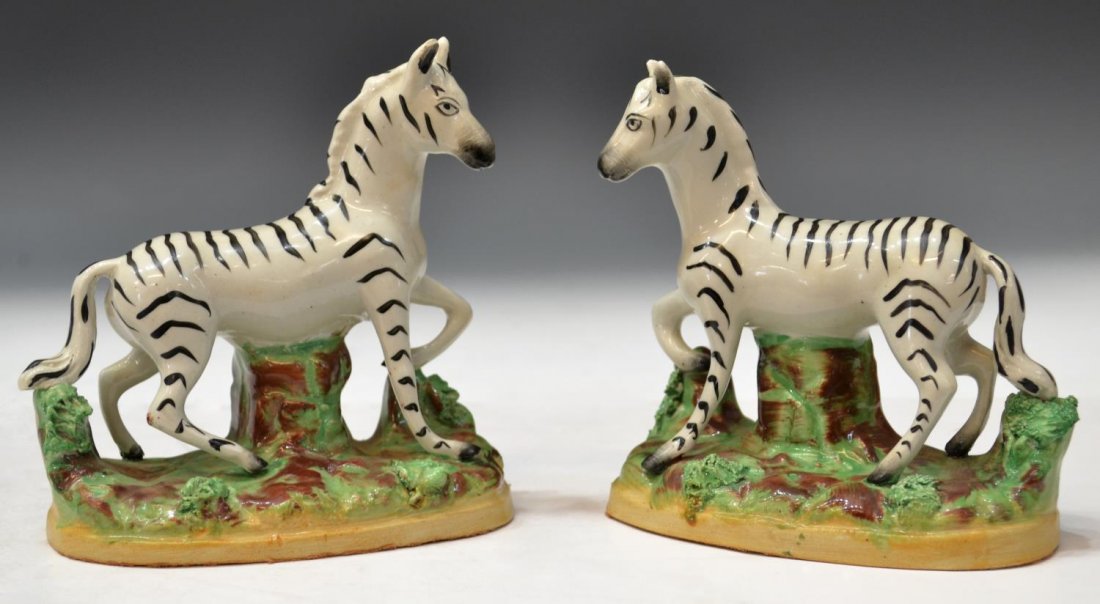 (2) SCARCE STAFFORDSHIRE POTTERY STANDING ZEBRAS: (pair) Staffordshire pottery zebras, standing in opposed positions, surmounting lush brown and green land, approx 5"h, 5"w, 2.5"d, 1.25lbs total *Provenance: The estate of Douglas B. Marshall (1917-20