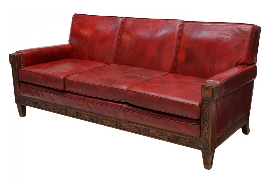 VINTAGE ROMWEBER OAK FRAMED LEATHER SOFA: Vintage Romweber oak and leather sofa, Batesville, Indiana, the skirt decorated with trailing grapevines and geometric carving, red leather loose cushions, 33"h, 78"w, 36"d *Provenance: The estate of