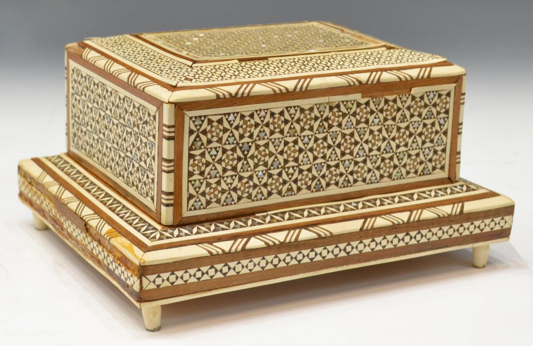 VINTAGE ARABESQUE INLAID MUSICAL CIGARETTE BOX: Inlaid musical cigarette box, the whole decorated with arabesque patterns of mother-of-pearl, wood, and bone inlay, the hinged lid revealing four slotted rows of storage, accommodating ten cigarettes,