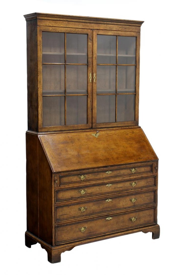 ENGLISH OAK FALL FRONT SECRETARY BOOKCASE: English style oak secretary bookcase, the molded cornice above mullioned doors, opening to simple shelving, the slant front desk with well fitted interior, over four drawers, raised on a bracket base,