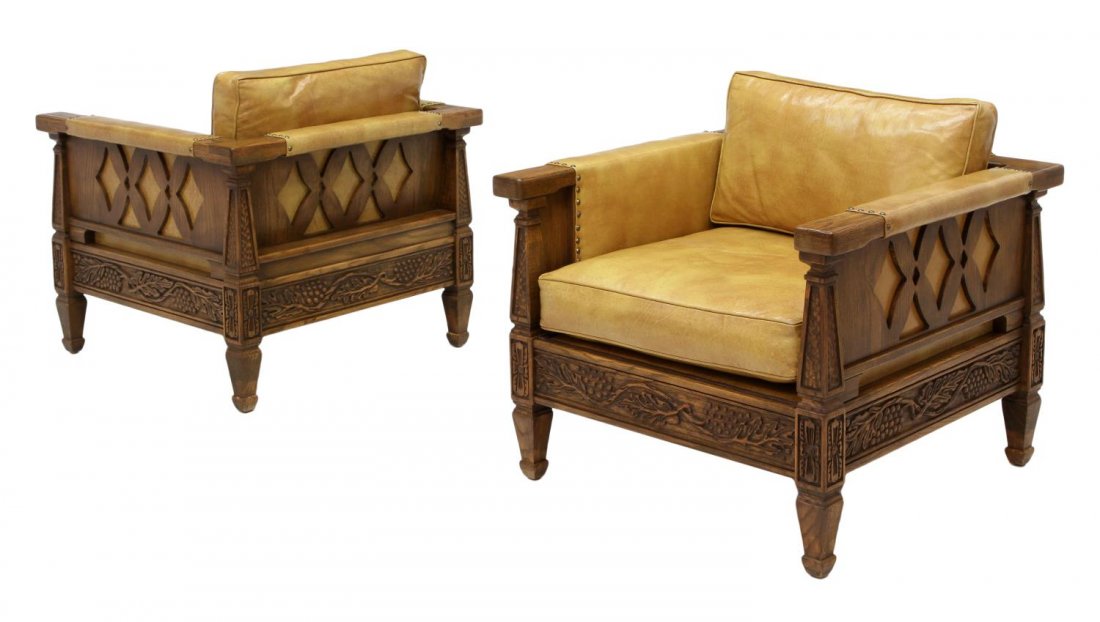 (PAIR) ROMWEBER OAK & LEATHER LOW BACK ARM CHAIRS: (pair) Vintage Romweber oak and leather arm chairs, Batesville, Indiana, c. 1978, carved with trailing grapevines, the low back chairs having a continuous back and arm rail with "X" form supports, tan