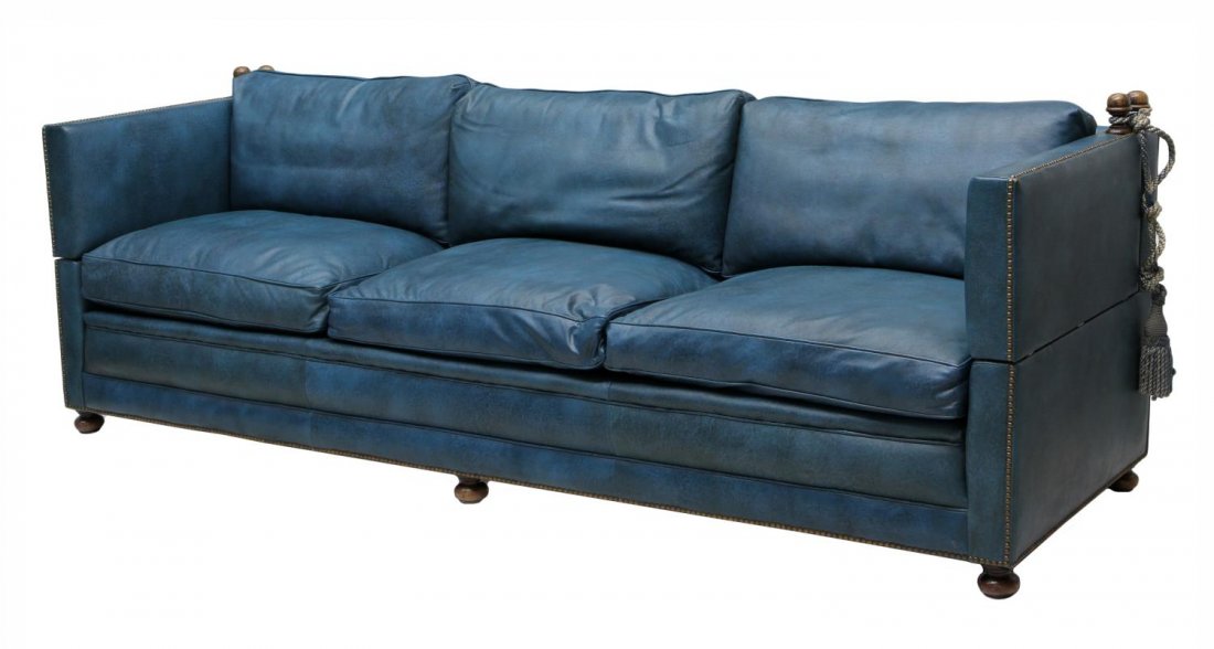 SPANISH LEATHER UPHOLSTERED DROP SIDE SOFA: Spanish cushioned sofa upholstered in blue leather, removable ties at corners secured to mounted finials allowing the sofa ends to drop, resting on bun feet, 33.75"h, 96.5"w, 30.5"d *Provenance: The e