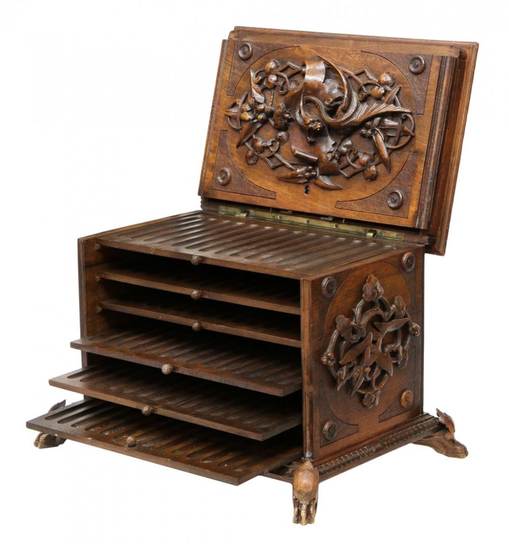 EXTRAORDINARY BLACK FOREST RELIEF FITTED CIGAR BOX: Extraordinarily fine and large Black Forest fitted cigar box, 19th c., ornamented borders on the sizeable case carved throughout in high relief with a large grotesque, winged griffin and foliated vine