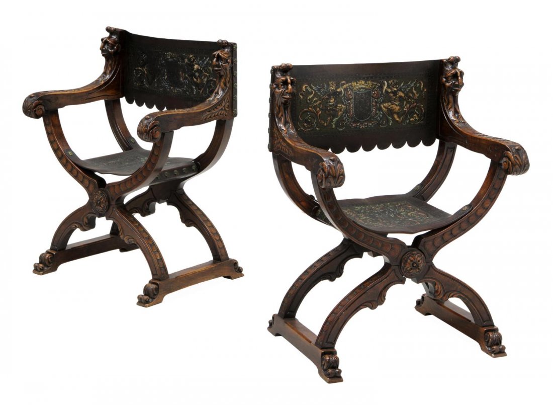 (PAIR) SPANISH EMBOSSED LEATHER FIGURAL ARM CHAIR: (pair) Spanish Renaissance Revival walnut armchairs, 19th c., polychrome embossed leather back and seat flanked by figural carved scrolled arms, a curule form frame, rising on stretcher joined stylize