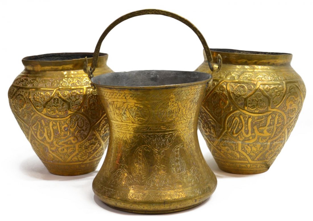 (3) MIDDLE EASTERN ARABESQUE RELIEF BRASS POTS: (lot of 3) Vintage Middle Eastern brass pots: (pair) having Arabic script and foliated motifs throughout, some wear, 11.75"h; (1) handled pot with spotted patination, 10.25"h; 21lbs total *Provenance: