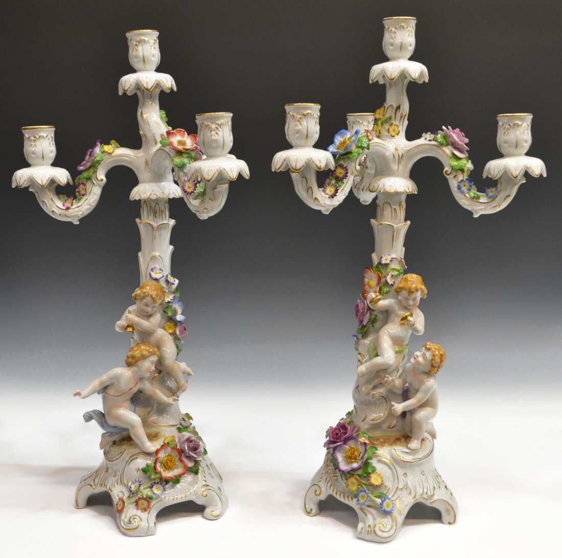 (PAIR) GERMAN PORCEALAIN FLORAL FIGURAL CANDELABRA: (pair) German parcel gilt porcelain four-light candelabra, Von Schierholz, applied polychrome floral detail surrounding two robust putti, removable tops, some loss to flowers, slight pitting, approx 2
