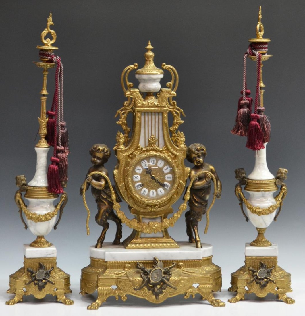 (3) BRASS & MARBLE GARNITURE CLOCK SET: (3) Brass and marble garniture clock set, sculptured satyrs flank the Louis XV style clock with rocaille embellishments, the clock face with Roman numerals on porcelain, time and strike works by Herml