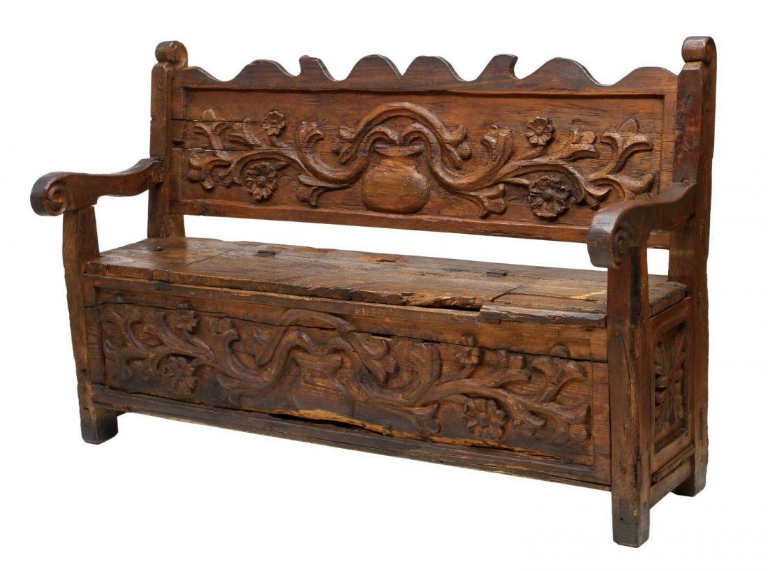 ANTIQUE CARVED PINE BENCH, 19TH C.: Rustic carved pine bench, likely Mexico, 19th c., relief carved foliage and flowers extending across the back board and front boards, the seat opening to storage, scrolled arms, block feet, pegged wit