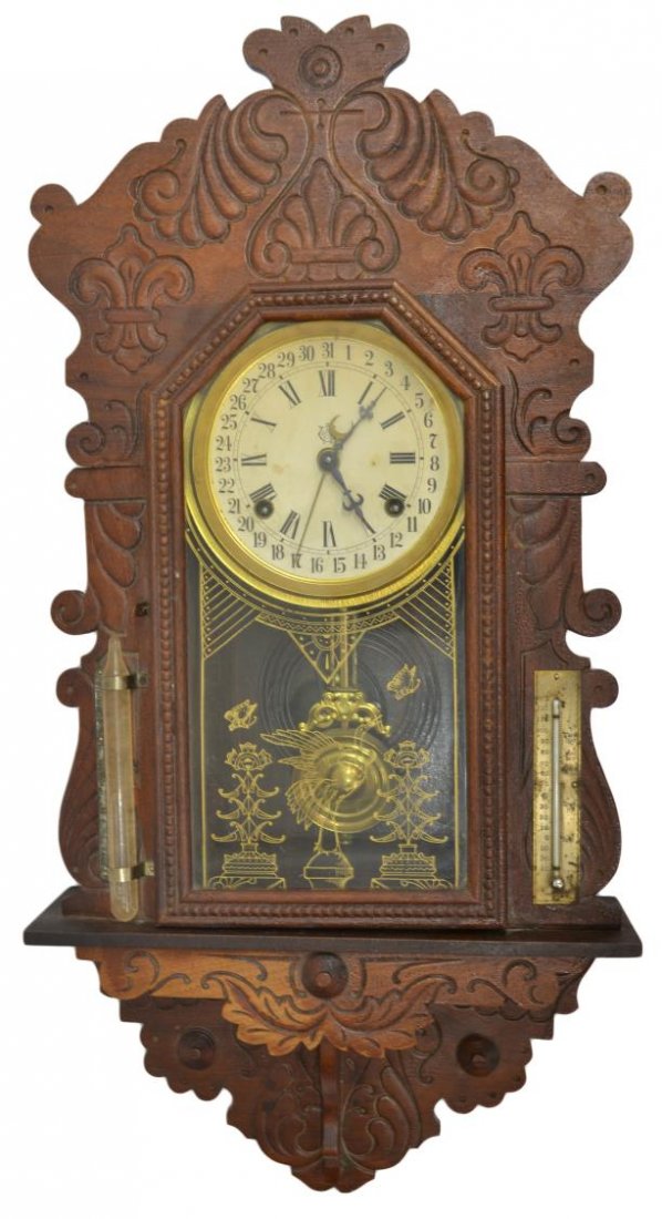 WATERBURY CALENDAR DIAL WALL CLOCK: Waterbury "Cato" model wall clock with calendar dial, 19th c., foliate press carved case, a thermometer and barometer mounted at either side, 26.5"h, 13.25"w, 4.25"d, 6lbs Start Price: $100.00