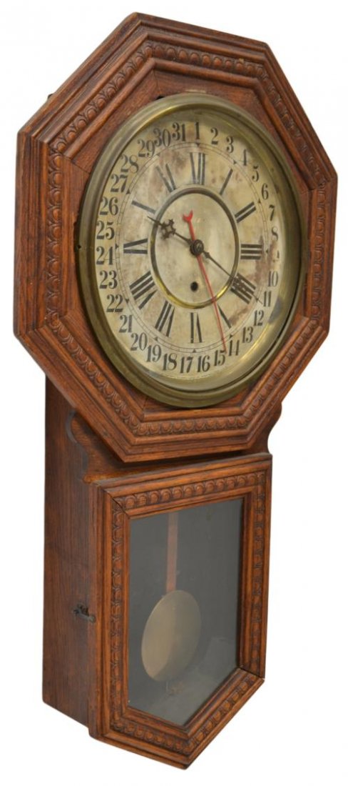 GILBERT CALENDAR DIAL OAK CASED WALL CLOCK: Gilbert oak cased wall clock with calendar dial and Roman numerals, time only movement, 32.5"h, 18.25"d, 4.5"d, 11.25lbs **Provenance: "Mesquite Charlie's" restaurant, 1986-2012, Pensacola, Florida**