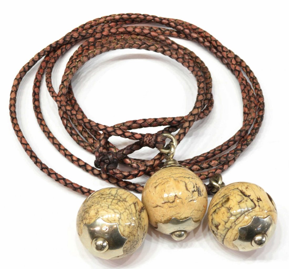 ARGENTINIAN BOLO, FOSSILIZED IVORY BALLS: Argentinian bolo, three fossilized ivory balls on braided leather, the balls held by hallmarked silver, ivory balls approx 2"d, total: 1.75lbs Start Price: $200.00
