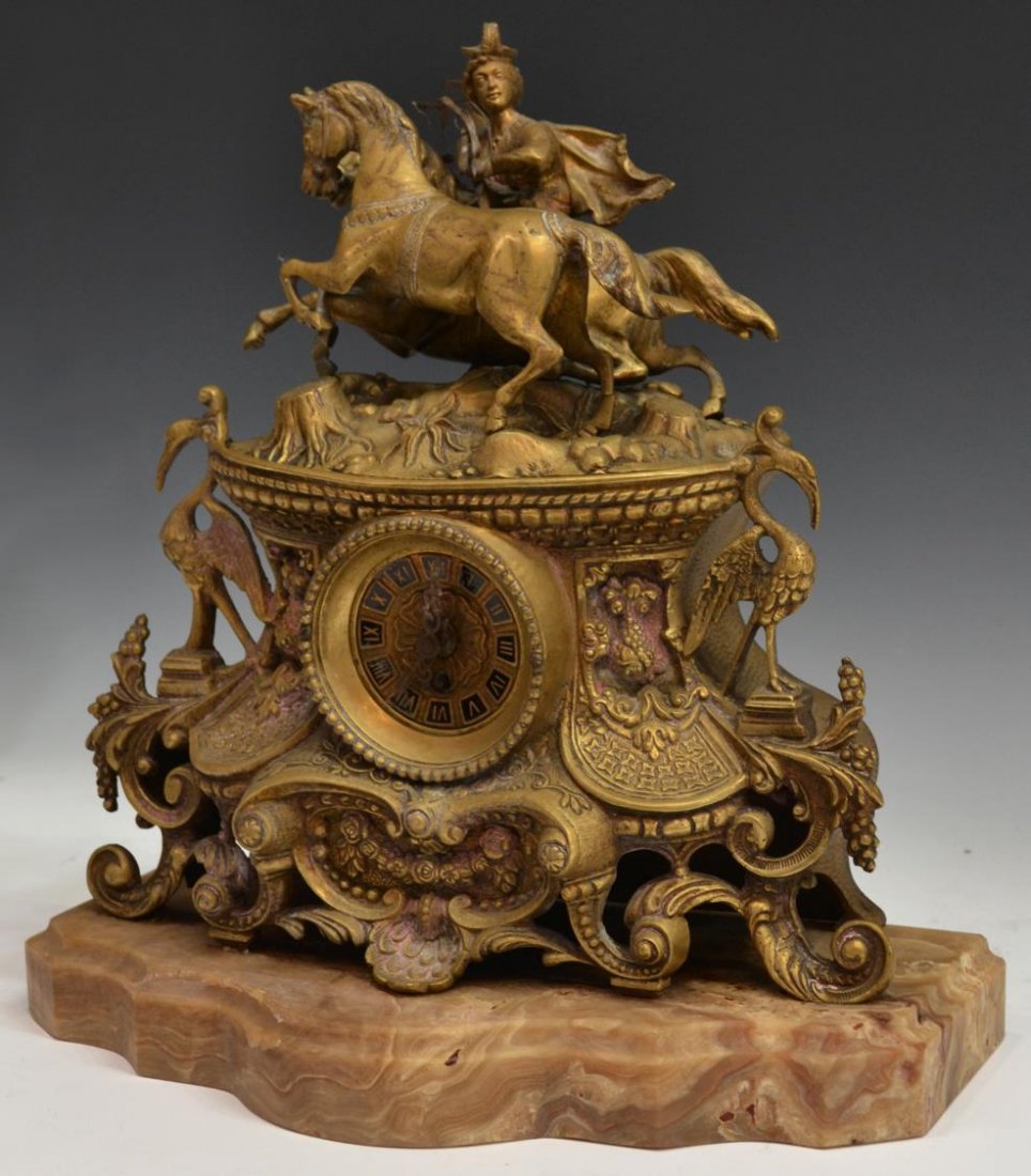 ANTIQUE CONTINENTAL FIGURAL BRASS CLOCK: Continental figural brass clock, 19th c., the foliate decorated works surmounted by two horses, one with rider, clock dial with Roman numerals on black reserves, time only German works, the clock case