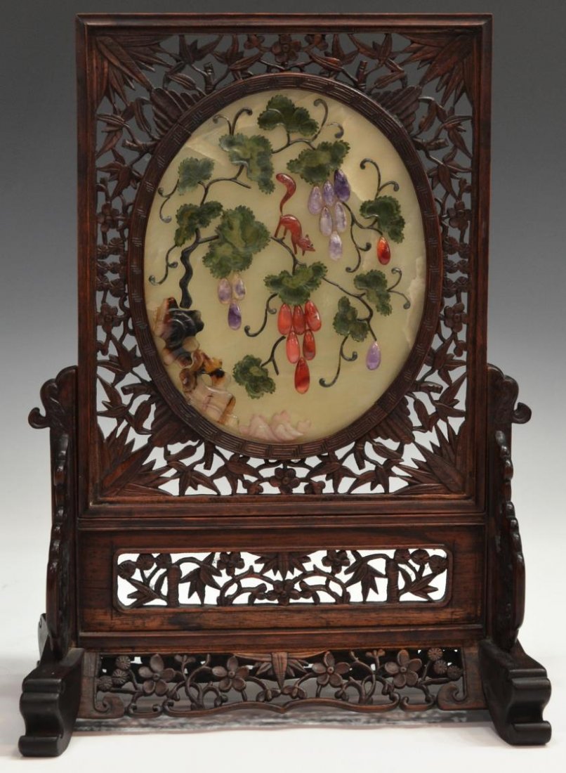 CHINESE JADE & MULTI STONE TABLE SCREEN: Chinese reticulated wood two-section table screen, 20th c., centered by a jade plaque featuring an animal upon fruited vines made of stone including jade, amethyst, agate and others, resting on the lo