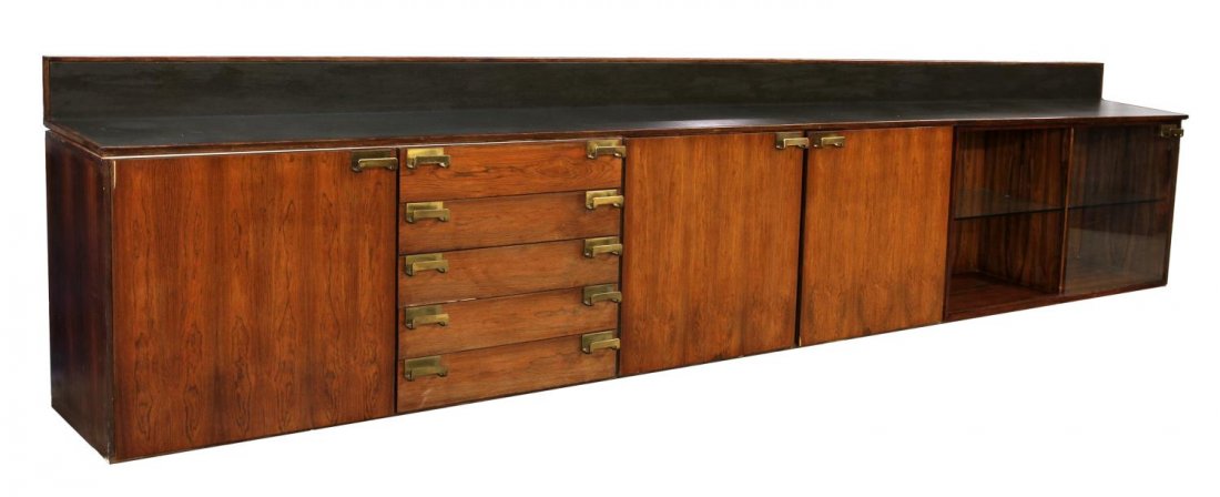 ITALIAN MID-CENTURY MODERN LONG SIDEBOARD: Italian mid-century rosewood sideboard of extensive length, lined rail and top, over two central doors, flanked by two doors and drawers on the left and glass shelves and door on the right, all openin