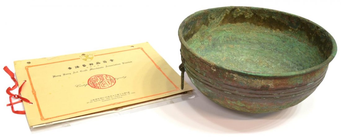 CHINESE HAN DYNASTY BRONZE BOWL & CERTIFICATE: Patinated Chinese bronze water bowl, Han Dynasty (B.C.E. 206-A.D. 220), circular decoration above two ring handles, substantial oxidation, together with a Certificate of Antiquity by the Hong Kong Art