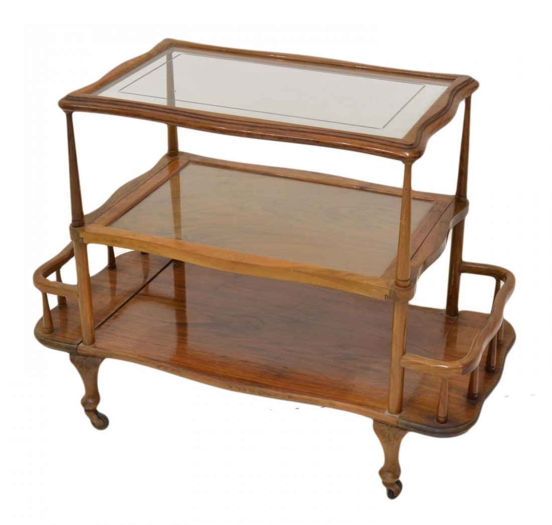 SPAIN FRUITWOOD THREE-TIER SERVICE CART: Northern Spain fruitwood three-tier rolling service cart, the shaped top with inset glass over a removable service tray, the lower shelf with extended spindle sides, scrolled supports on castors, 27.5