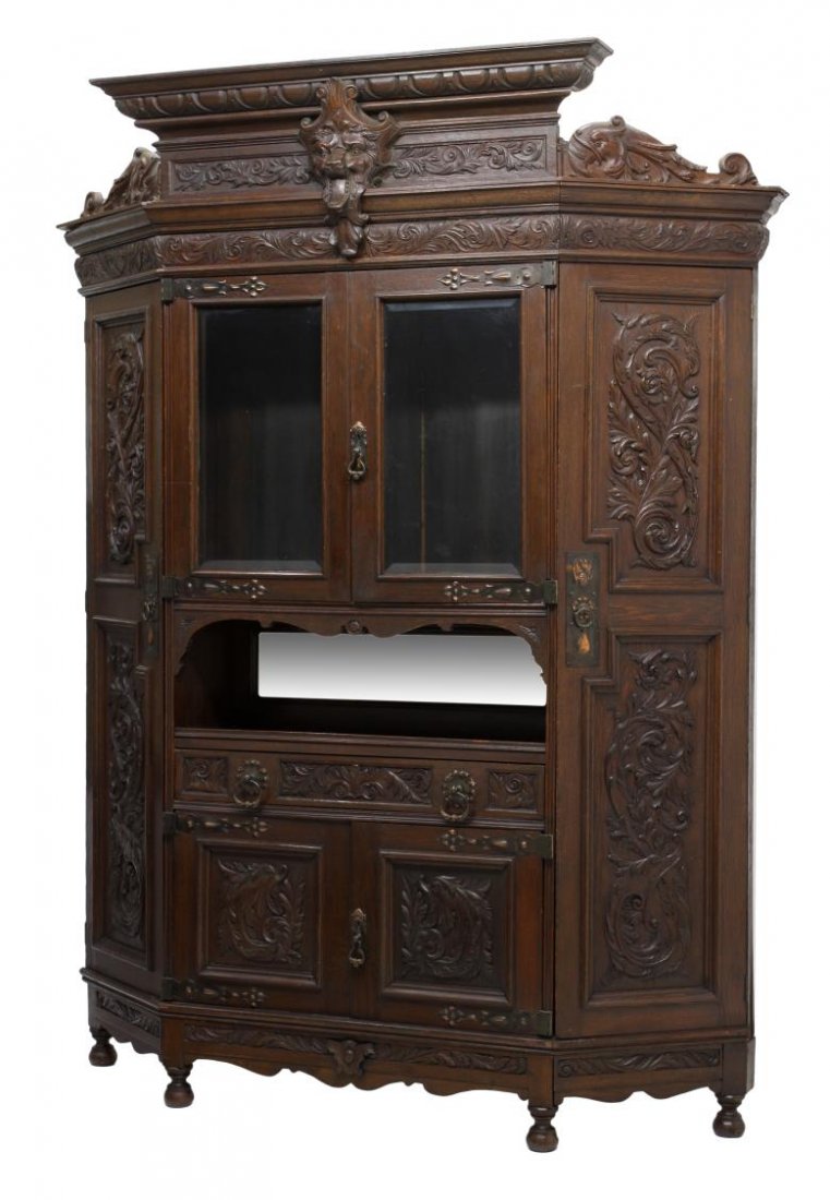ITALIAN RENAISSANCE REVIVAL OAK DISPLAY CABINET: Italian Renaissance Revival oak display cabinet, 19th c., stepped cornice over a foliate carved frieze, fronted with two beveled glass doors, a central mirror with shelf, the lower section with two ca