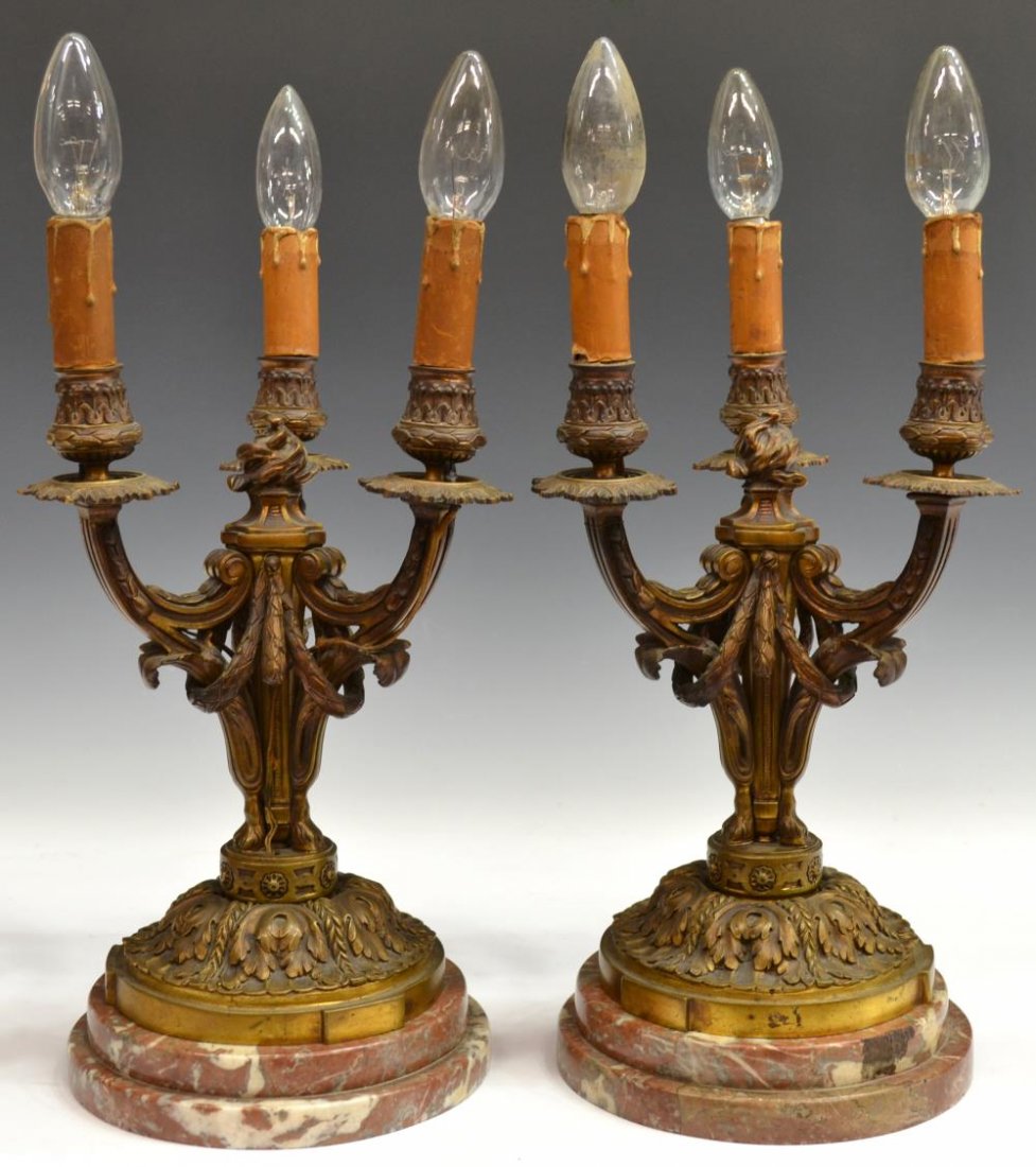 (2) CONTINENTAL GILT BRONZE FOLIATED TABLE LIGHTS: (pair) Neoclassical style gilt bronze three-light table lamps, early 20th c., ribbed and foliate arms issuing lights, raised on hoofed feet, circular base having elaborate foliate decoration, removabl