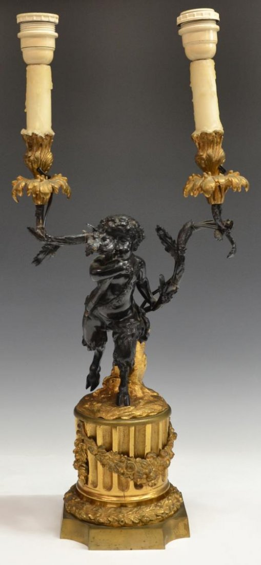 LOUIS XVI STYLE GILT & BRONZE FIGURAL TABLE LAMP: Louis XVI style gilt bronze two-light table lamp, early 20th c., the base modeled as an architectural column hung with a flowering festoon, standing atop is a bronze satyr figure holding two foliate g