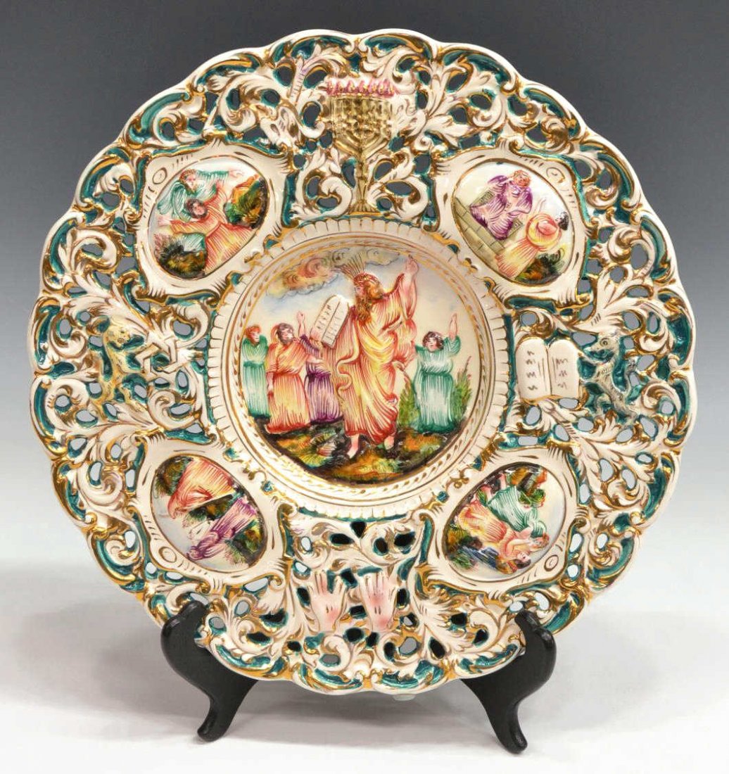 CAPODIMONTE MOSES TEN COMMANDMENTS PLATE: Capodimonte parcel gilt ceramic charger, 20th c., central relief of Moses holding the Ten Commandments with four religious scenes on surrounding reserves, a menorah at top, gilt lettering at verso "Ca