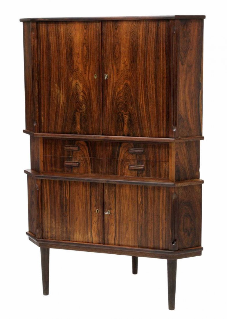 DANISH MID-CENTURY MODERN ROSEWOOD CORNER CABINET: Danish mid-century modern rosewood corner cabinet, having upper and lower cabinet sections, bank of four small drawers, on tapered legs, 53.5"h, 35.75"w, 25.25"d Start Price: $300.00