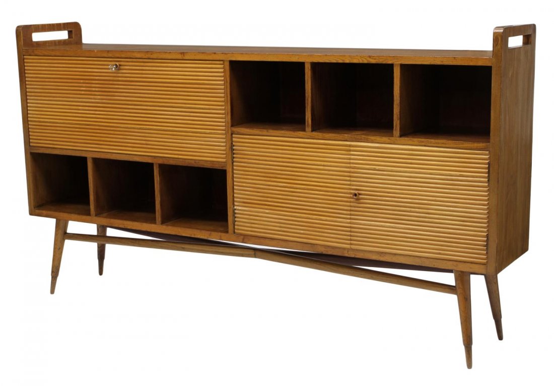 ITALIAN MID-CENTRY MODERN SIDEBOARD: Italian mid-century modern oak sideboard, c. 1950, rectangular the front with storage slots, horizontally grooved doors and drop front opening to fitted interiors, rising on stretcher jointed tapered 