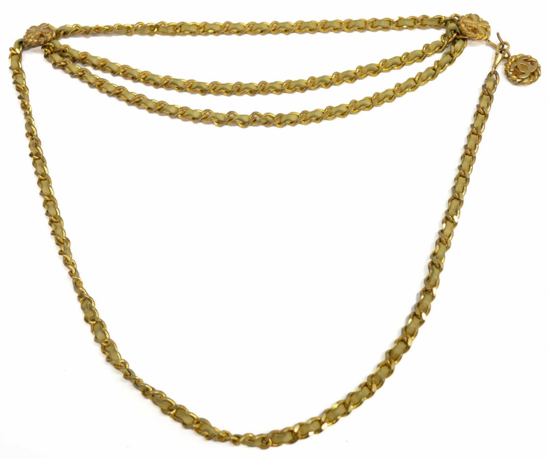 VINTAGE CHANEL FOUR LEAF CLOVER CHAIN BELT: Vintage Chanel gold tone metal coin medallion belt, two shamrock medallions on either side of the triple chain woven with tan leather, the hook is stamped with the Chanel logo, openwork Chanel logo wi