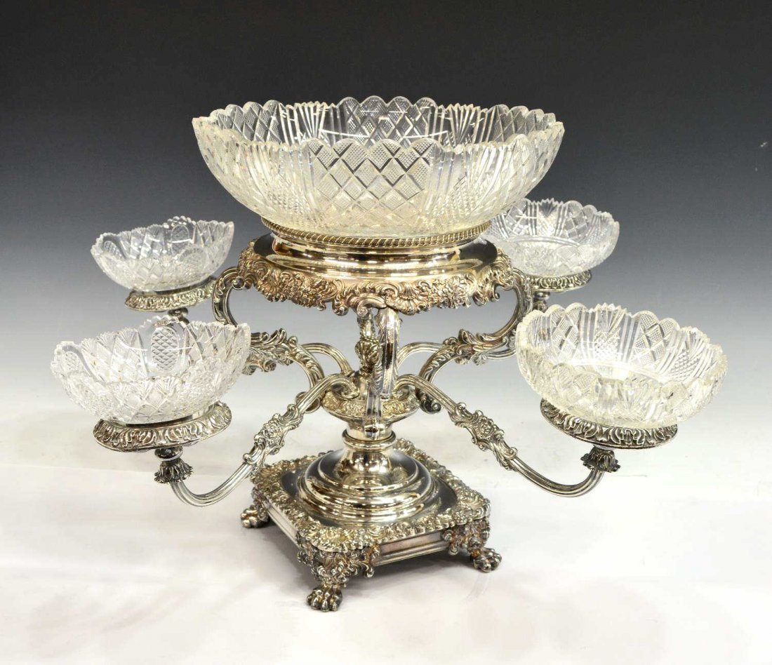 GEORGIAN STYLE SILVERPLATE & CUT GLASS CENTERPIECE: Georgian style silver plate and cut glass epergne centerpiece, large cut glass center bowl cut in a diamond and fan pattern, four scrolled arms hold similarly patterned bowls, the square frame having 