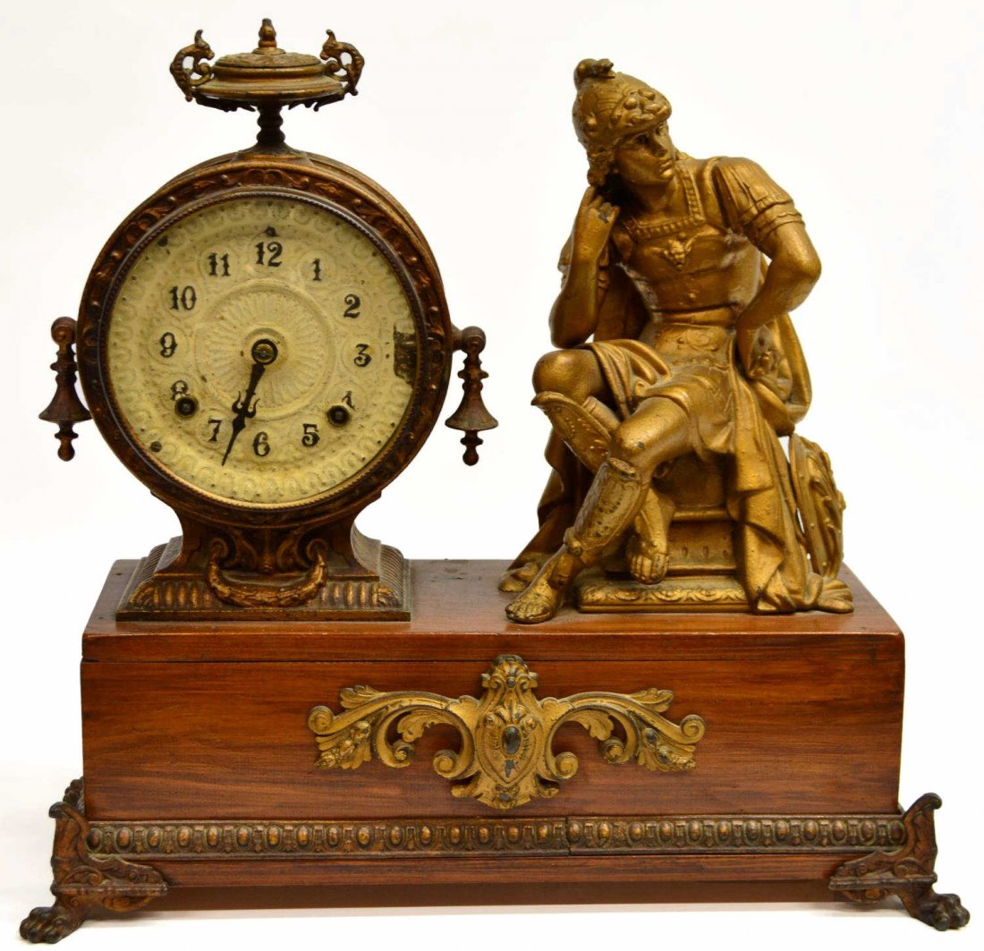 ANSONIA FIGURAL MANTLE CLOCK: Ansonia figural mantle clock, 19th c., the circular case housing time and strike works, a seated gilt figure on the wood case is often identified as Mercury, paint loss at dial, 16"h, 17.5"w, 7.25"d, 