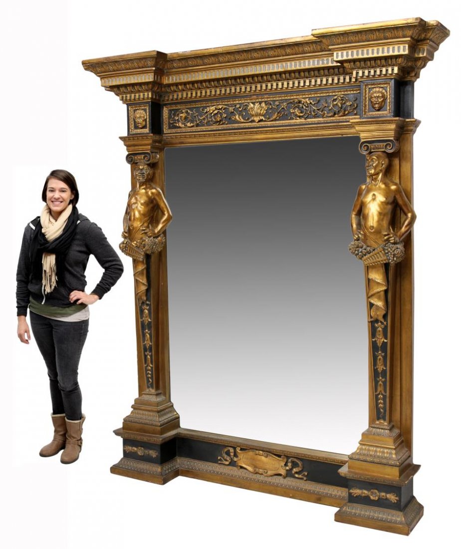 MONUMENTAL RENAISSANCE STYLE GILT FIGURAL MIRROR: Monumental Renaissance Revival style parcel gilt wall mirror, late 20th c., the stepped cornice with dentil moulding over a masque and foliate frieze, central beveled mirror flanked by large figural p