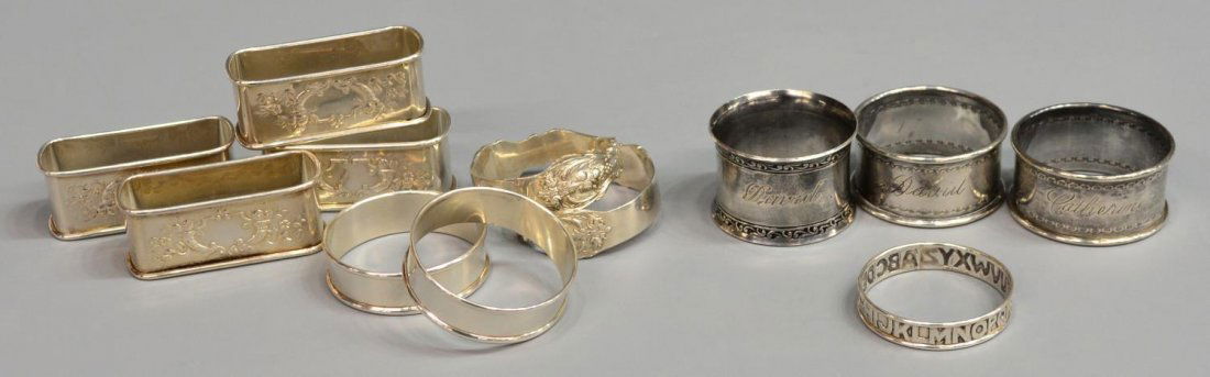 (12)COLLECTION STERLING SILVER NAPKIN RING HOLDERS: (lot of 12) Sterling silver napkin ring group, varied makers, sizes and styles, several sets including (2) engraved circular, (4) of rectangular form, (2) simple circular, (2) Reed & Barton, (1) ABC"s