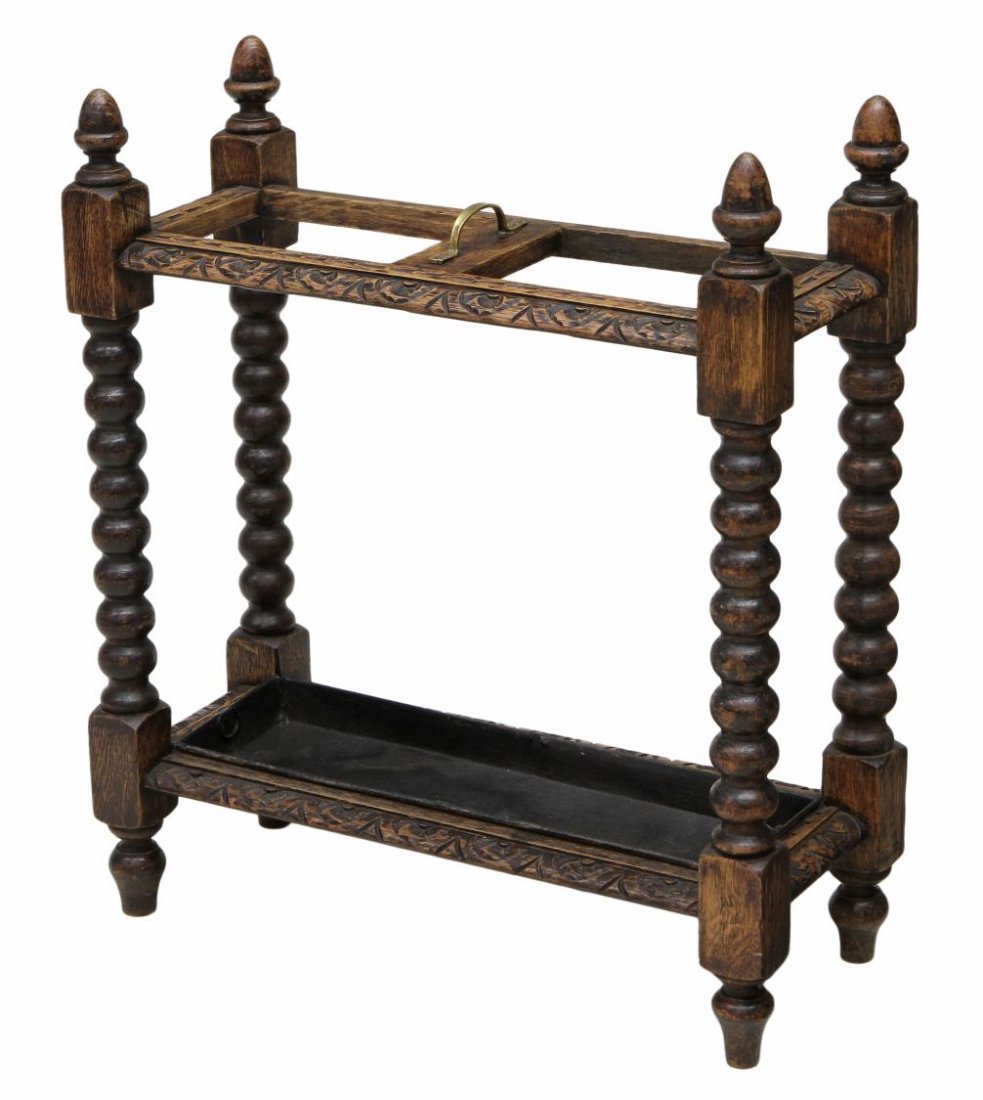 EDWARDIAN OAK FOLIATE CARVED UMBRELLA STAND: Edwardian oak foliate carved umbrella stand, early 20th c., acorn finials at each corner, two umbrella wells with a lower drip fan, rising on bulbous legs, 27.5"h, 24"w, 10"d Start Price: $100.00
