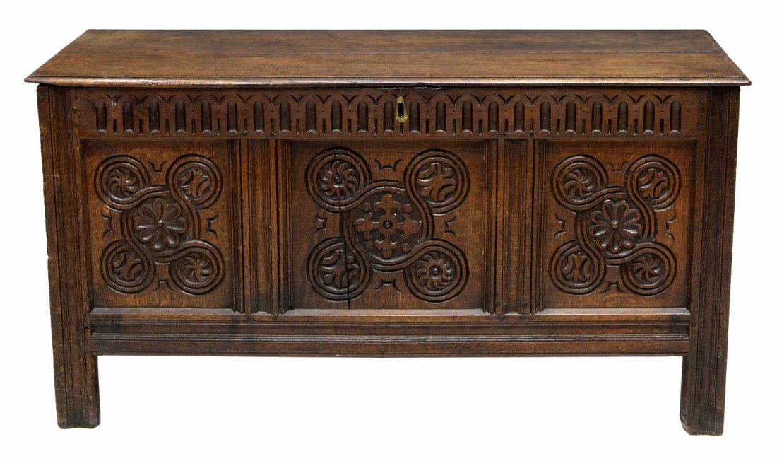 18TH C. OAK CARVED BLANKET BOX: British oak trunk or blanket box, late 18th c., the front with foliate and geometric carving, two board top with strap hinges opening to the box fitted interior with original lock, rising on block leg