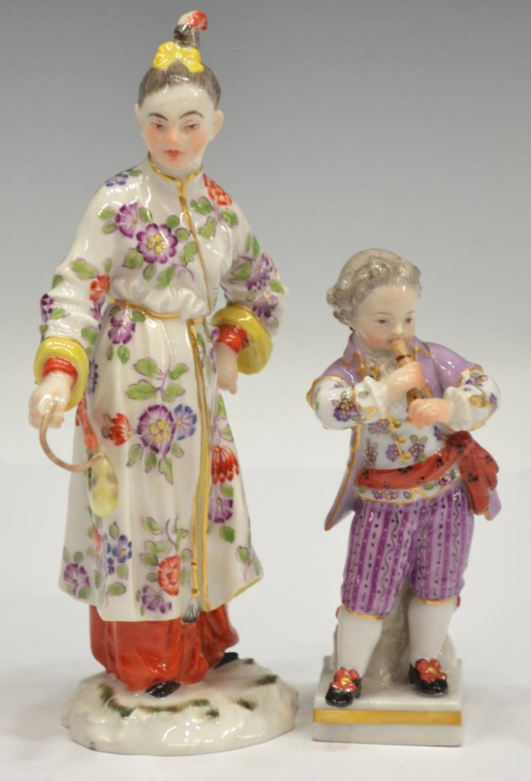 (2) MEISSEN PORCELAIN FIGURES IN ELABORATE DRESS: (lot of 2) Meissen porcelain cabinet figures: (1) diminutive figure of a young flute player, on square base, 4"h; (1) figure elaborately costumed in floral decorated robe, holding a fish, loss to porc
