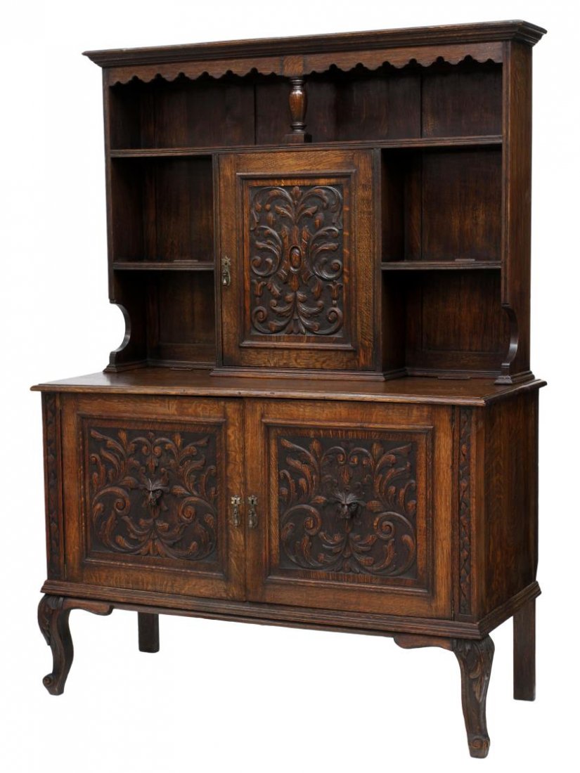 FINELY CARVED 19TH C. OAK WELSH STYLE DRESSER: Victorian carved oak Welsh style cupboard, 19th c., having a display back with stepped cornice over open shelves with a single foliate carved door, the lower cabinet with two doors with heavy foliate 