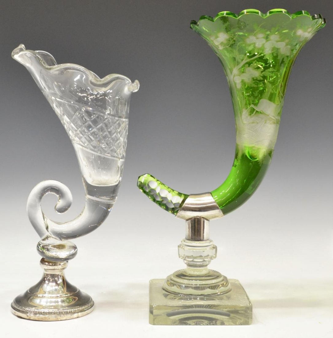 (2) BOHEMIAN & CUT GLASS CORNUCOPIA CENTER PIECES: (lot of 2) Cut glass cornucopia vases, comprising: (1) Bohemian emerald cut to clear cornucopia vase, decorated with wildlife scenes in a forest, mounted on a square clear glass base with a sterling c