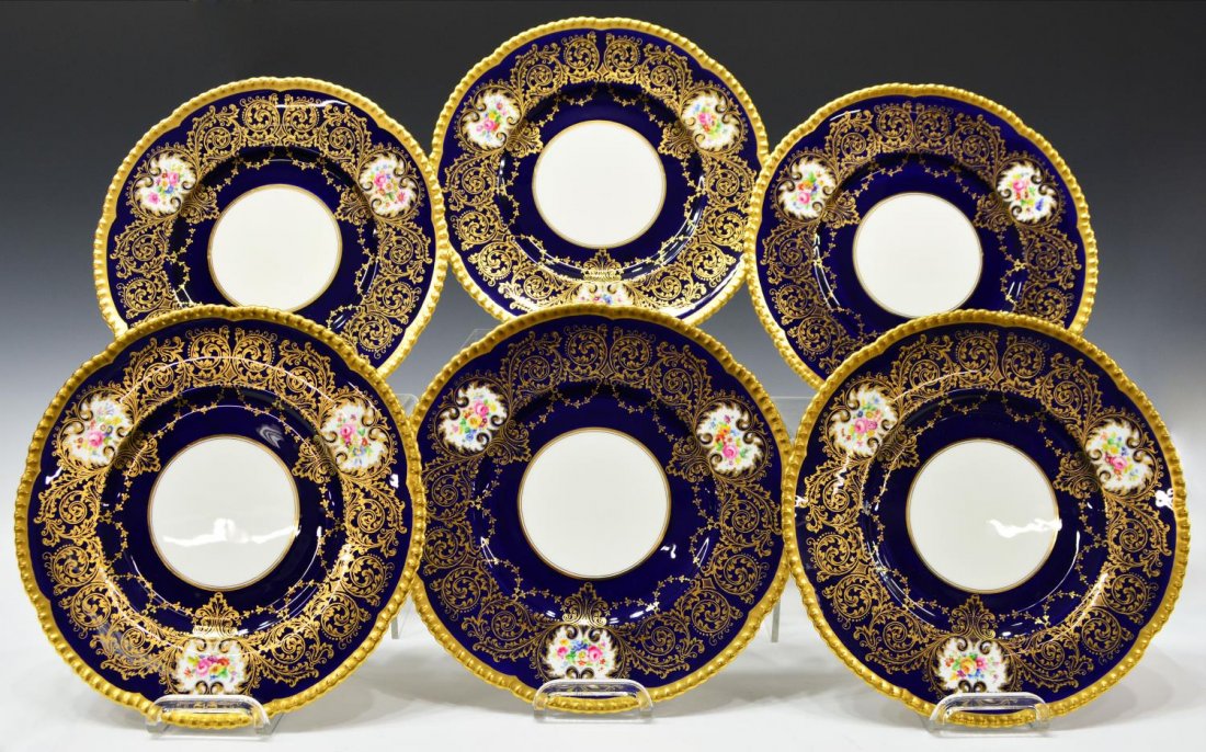 (6) ENGLISH CAULDON COBALT & GILDED SERVICE PLATES: (set of 6) English Cauldon china dinner plates, three hand painted floral reserves surrounded by a border of scrolling gilt foliage on a cobalt ground, signed A. Winkle, pattern number V8319 B, 10.75"