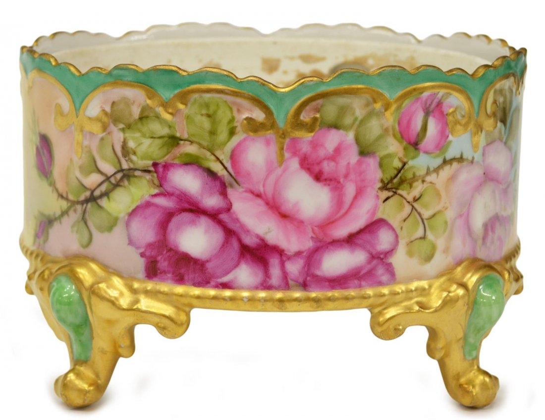 A. KLINGENBERG LIMOGES GILT & FLORAL PLANTER: Limoges France planter, A. Klingenberg, the circular frame hand painted with pink, yellow and purple flowers and green foliage, gilt and turquoise toned trim, rising on four gilt scrolled feet, marked